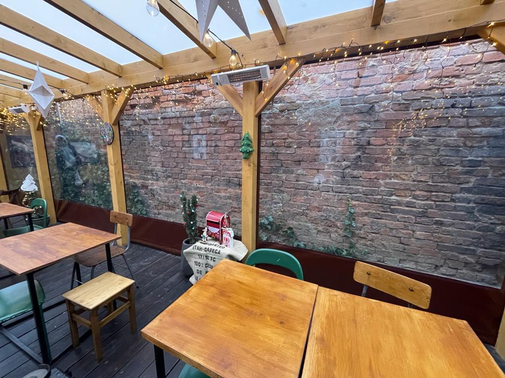 zdjęcie ogródka restauracyjnego od środka obudowanego przeźroczystą plandeką