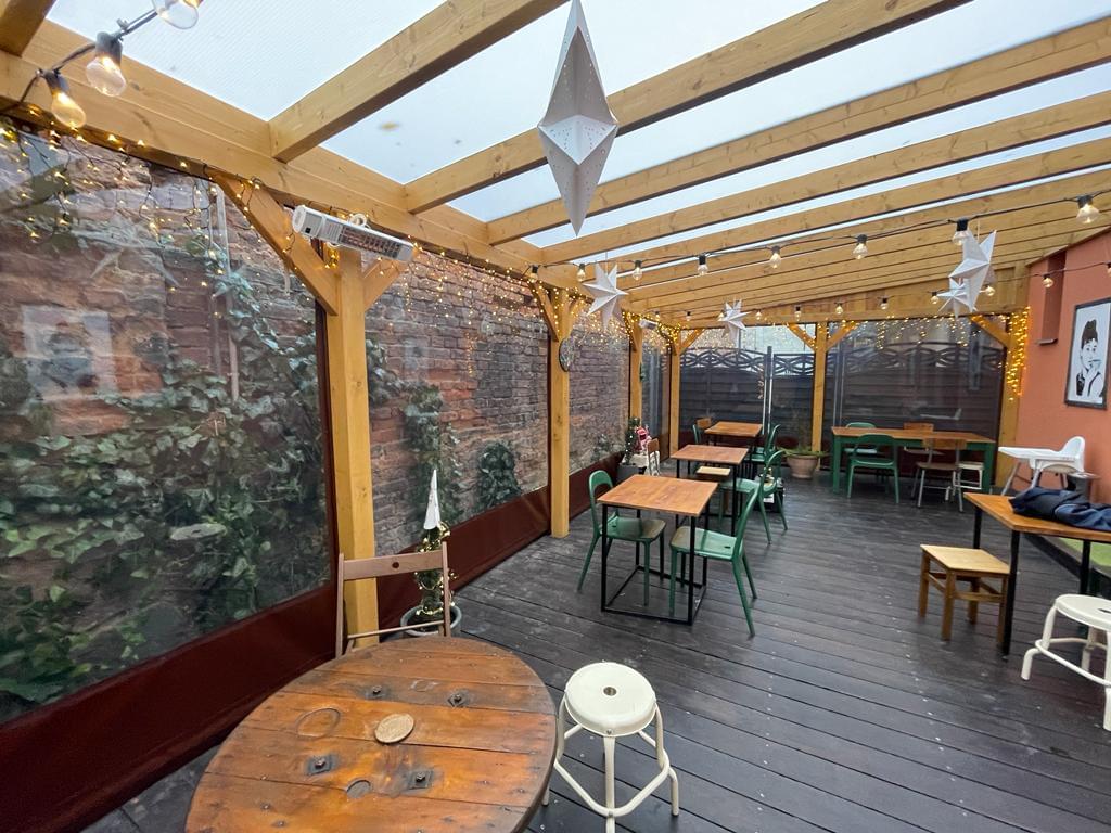 zdjęcie ogródka restauracyjnego od środka obudowanego przeźroczystą plandeką