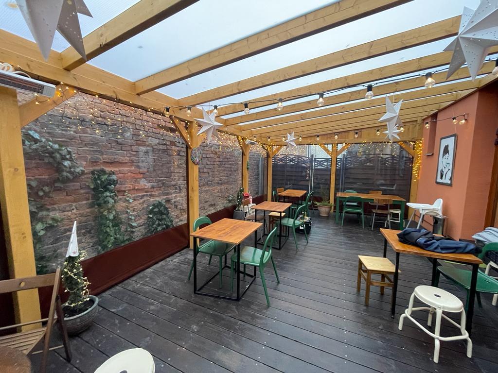 zdjęcie ogródka restauracyjnego od środka obudowanego przeźroczystą plandeką