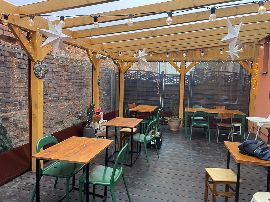 zdjęcie ogródka restauracyjnego od środka obudowanego przeźroczystą plandeką