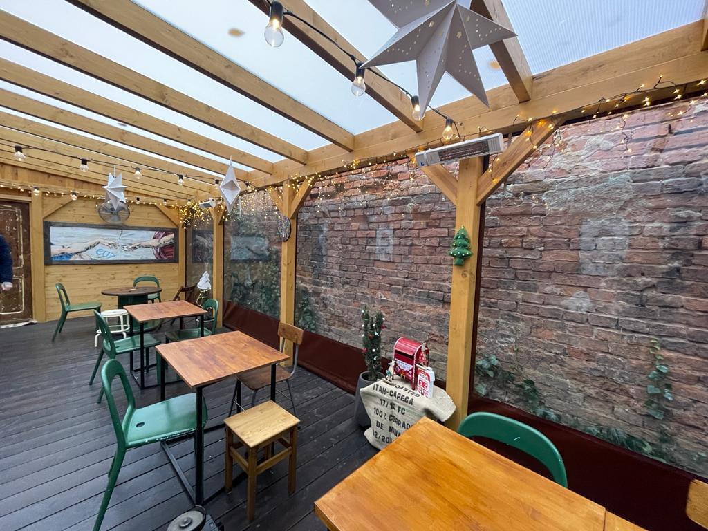 zdjęcie ogródka restauracyjnego od środka obudowanego przeźroczystą plandeką